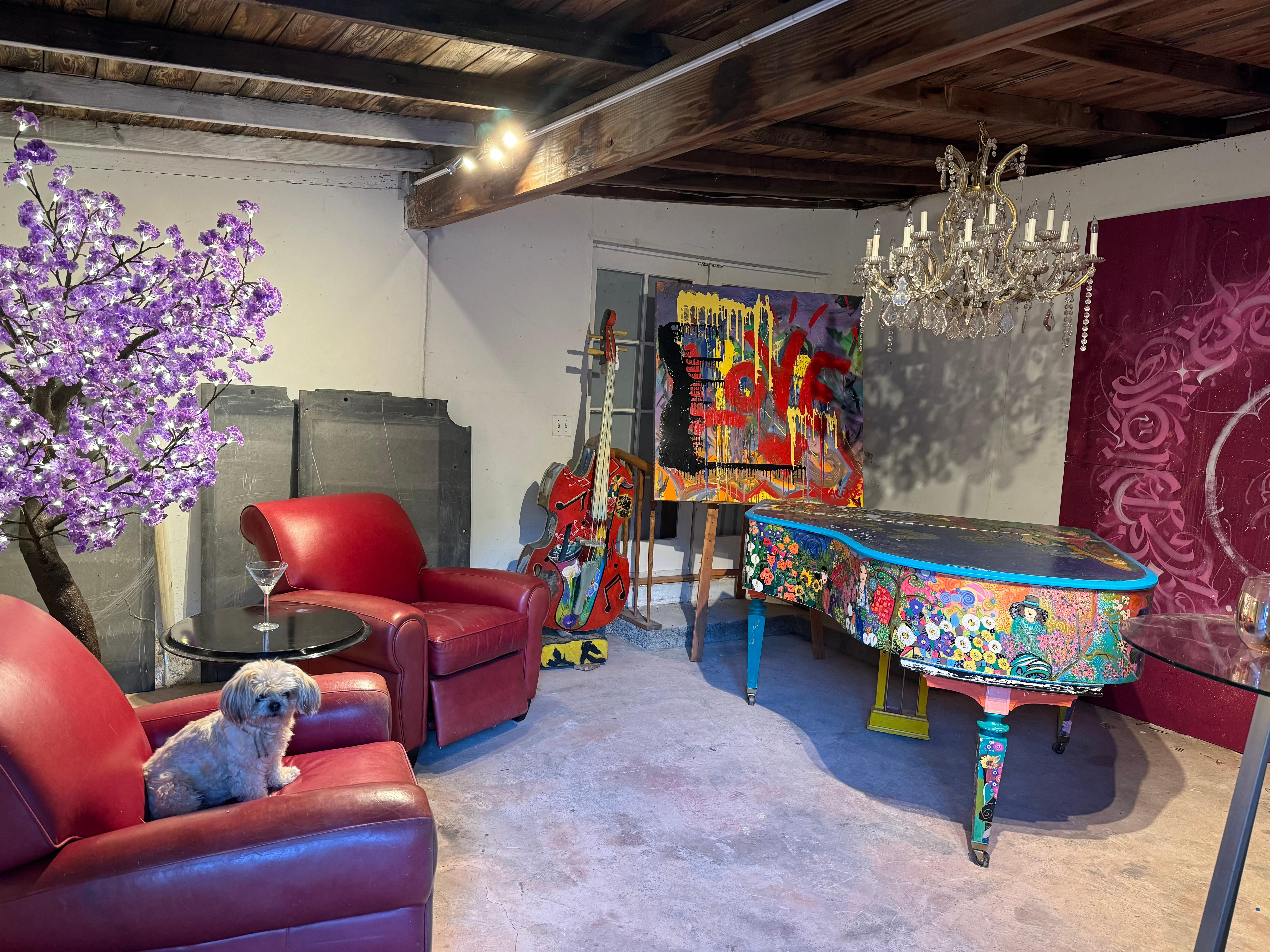 WaterWise art lounge with a hand-painted grand piano, painted bass, LOVE canvas and blossom tree
