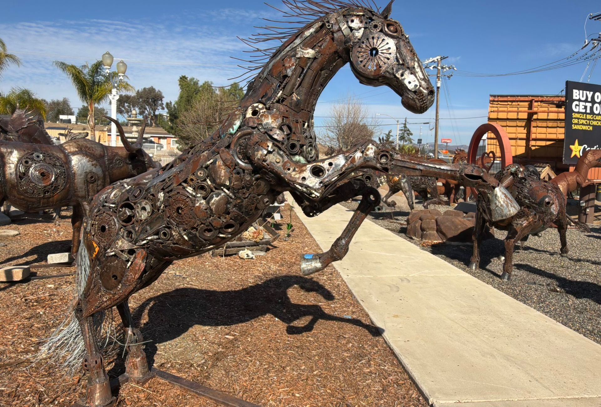 Recycled metal horse sculptures along the showroom walkway